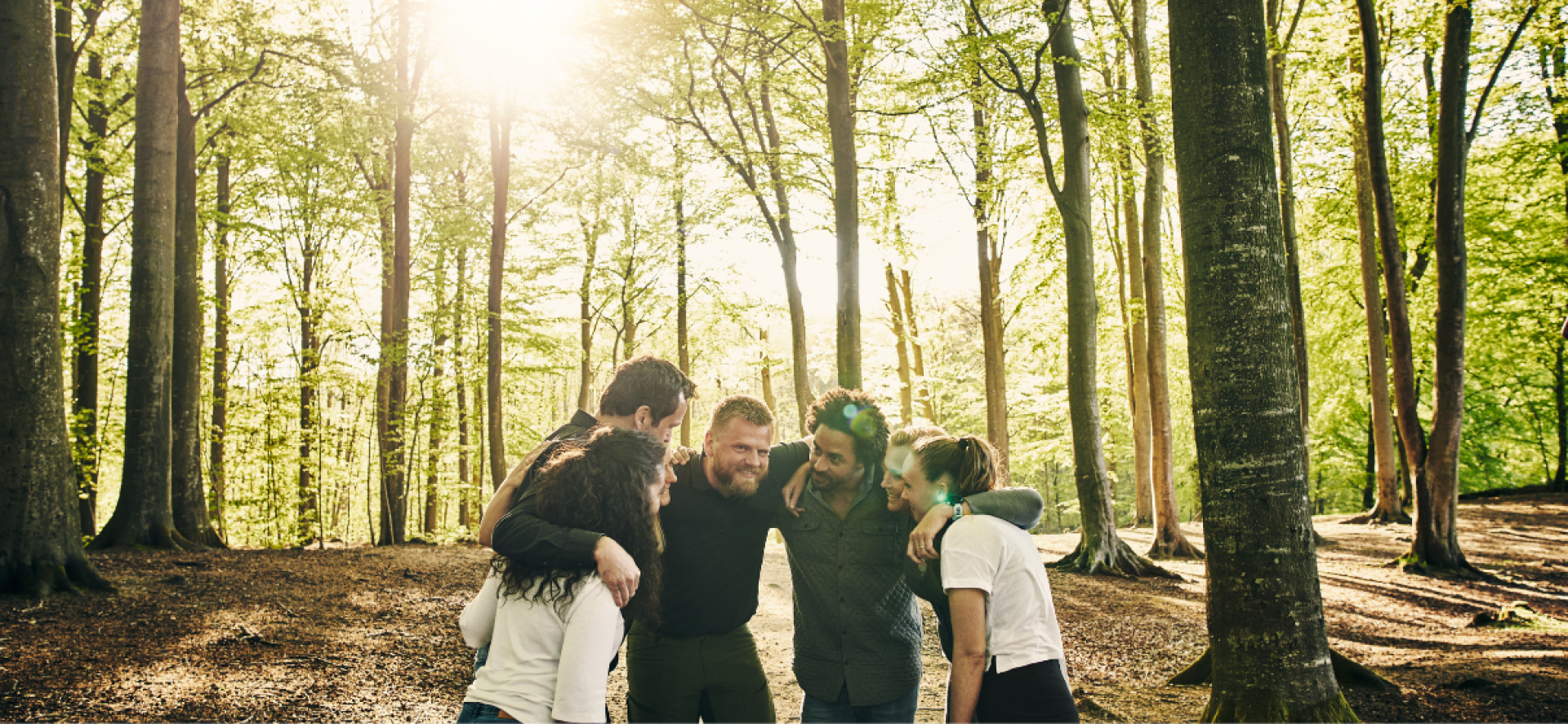 a group of people huddled together in nature, representing charity insight