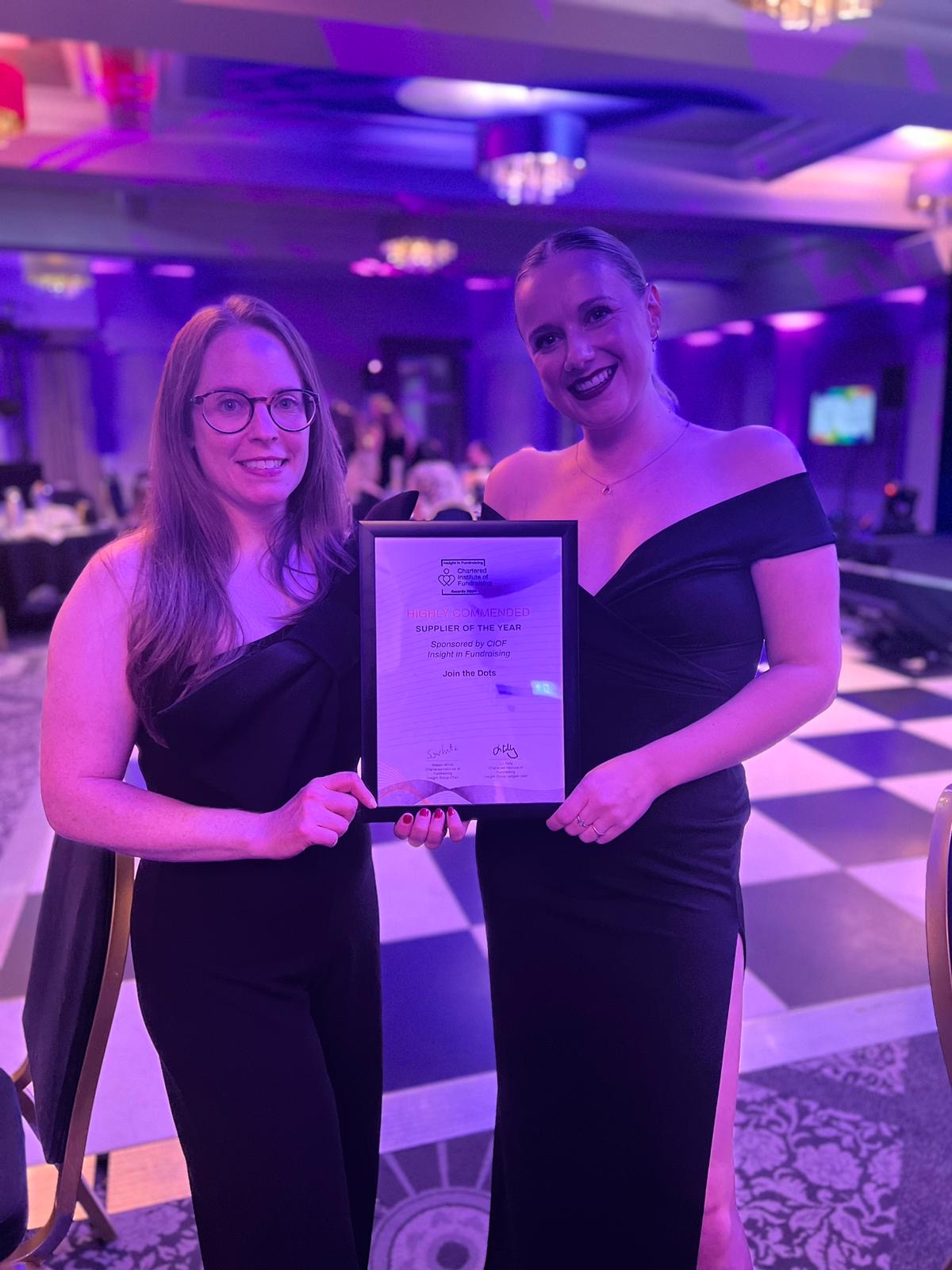 Two women hold a certificate 