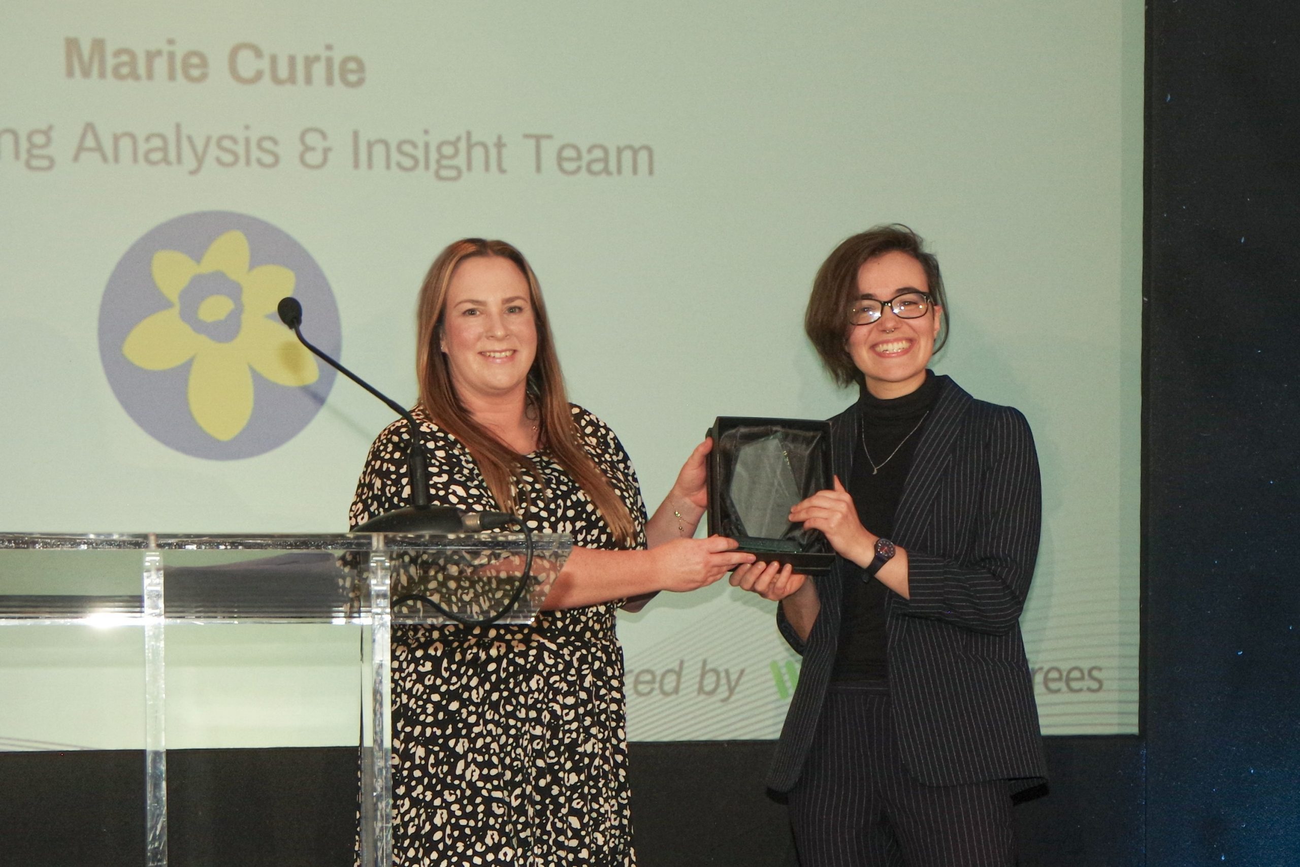 Two women on stage with an award 