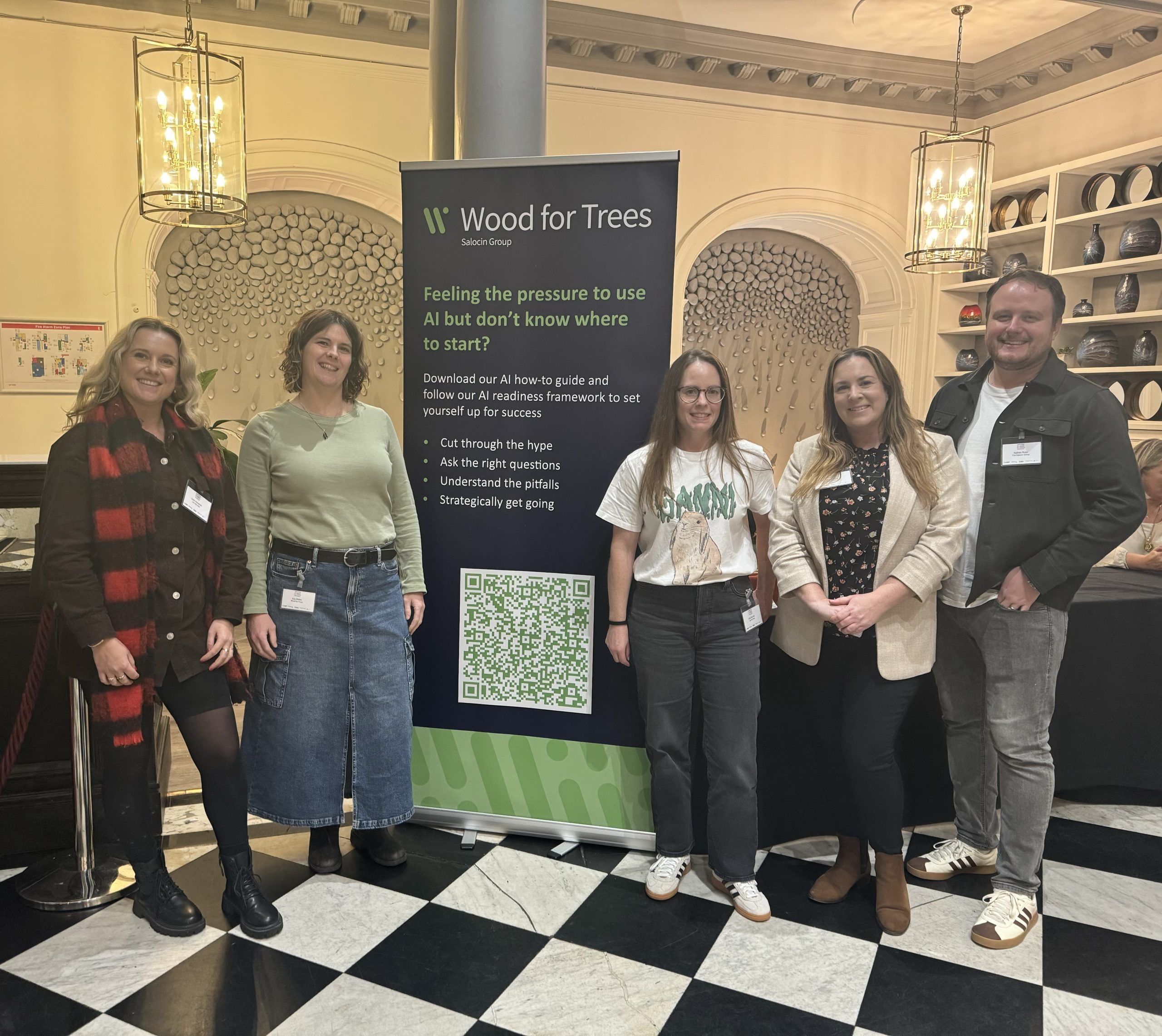 Five people standing with a Wood for Trees banner