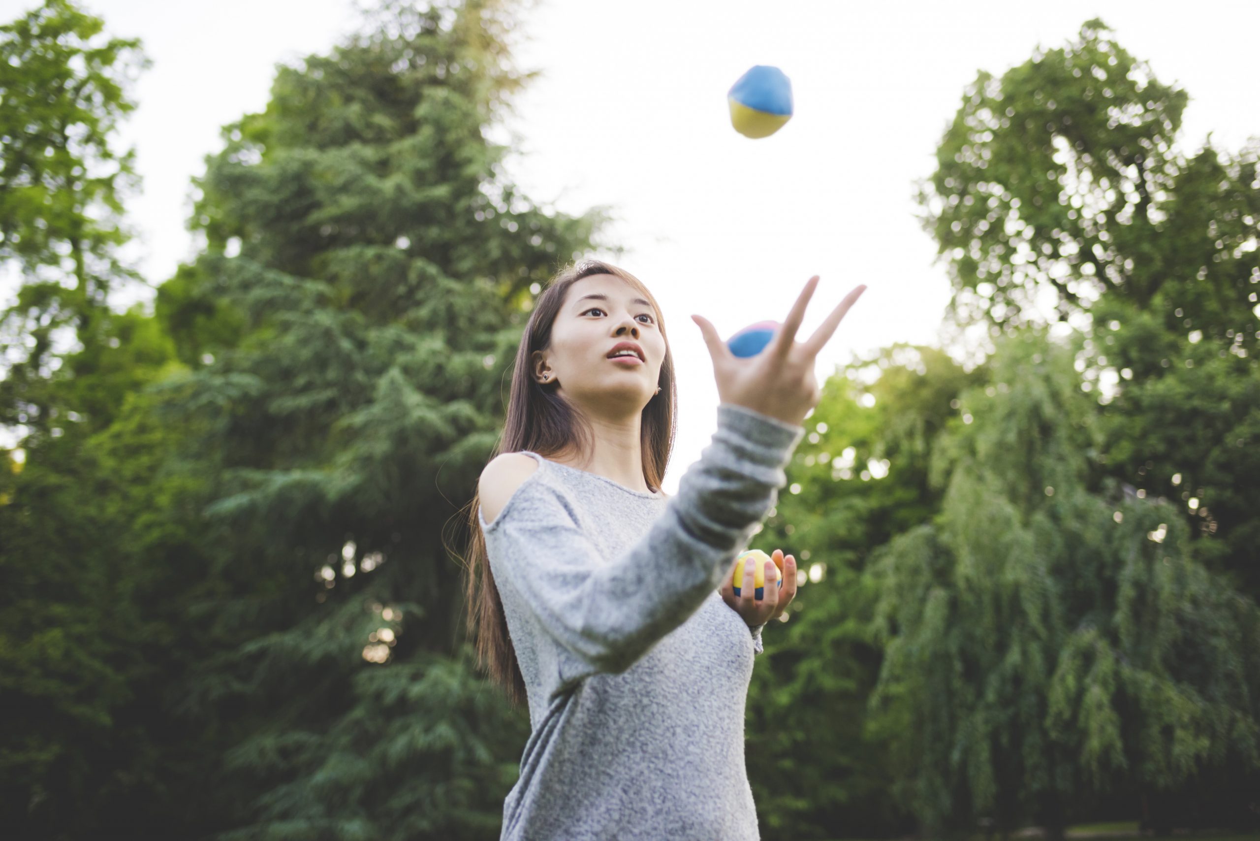 A woman juggles in the park 